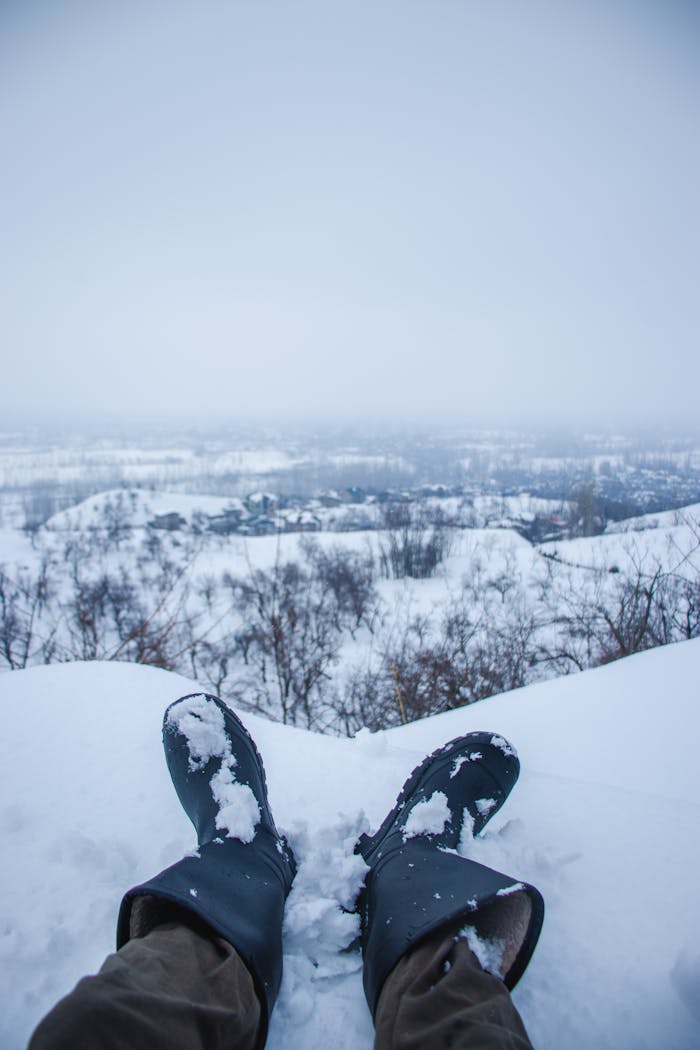 Snowy landscape view from Srinagar featuring boots in the foreground, highlighting winter tranquility.
